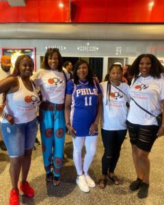 Women posting for a photo at a basketball stadium