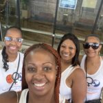 Four women wearing white outfits